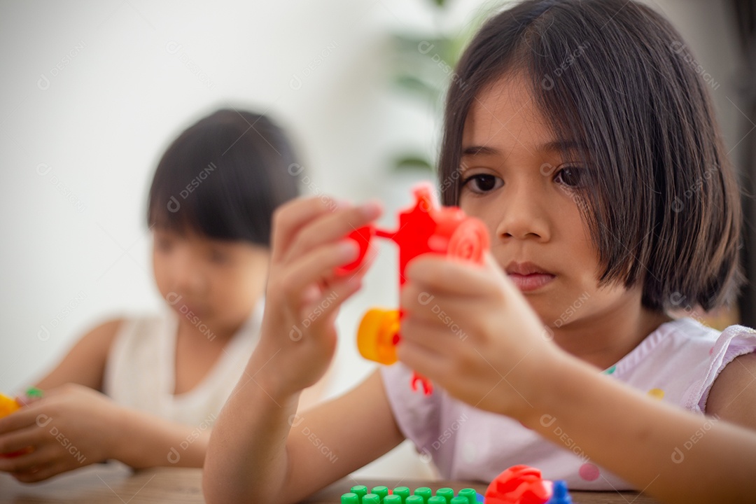 Adorável menina jogando blocos de brinquedo em uma sala iluminada