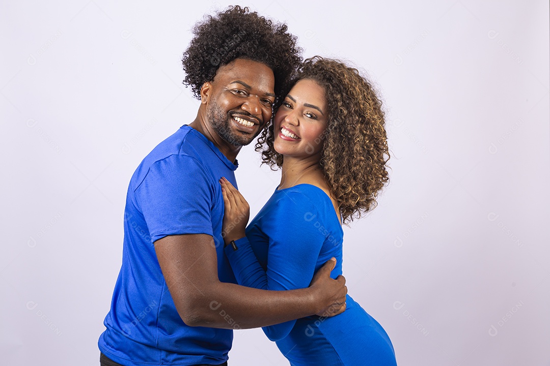 Casal sorridentes com blusa azul em fundo branco