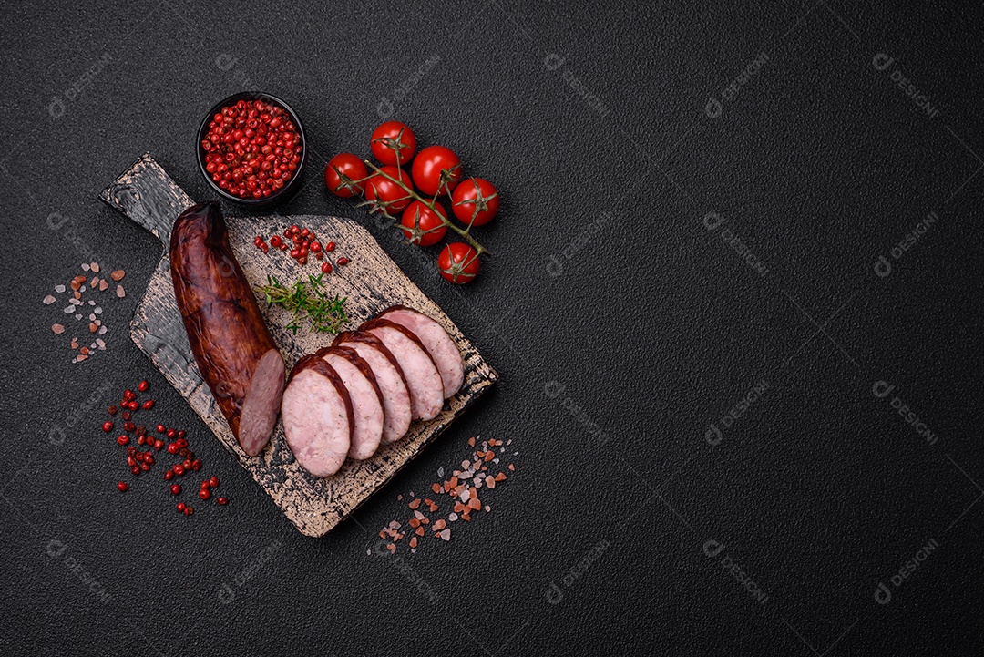 Deliciosa salsicha defumada com sal e especiarias cortadas em fatias sobre um fundo escuro de concreto