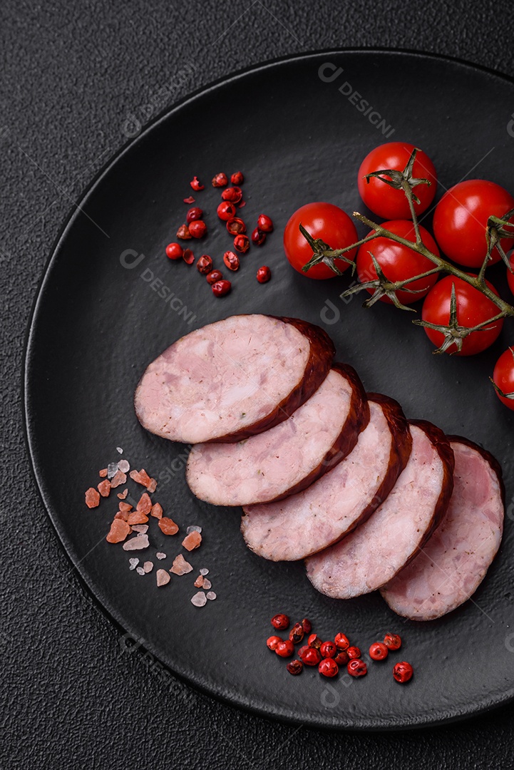 Deliciosa salsicha defumada com sal e especiarias cortadas em fatias sobre um fundo escuro de concreto