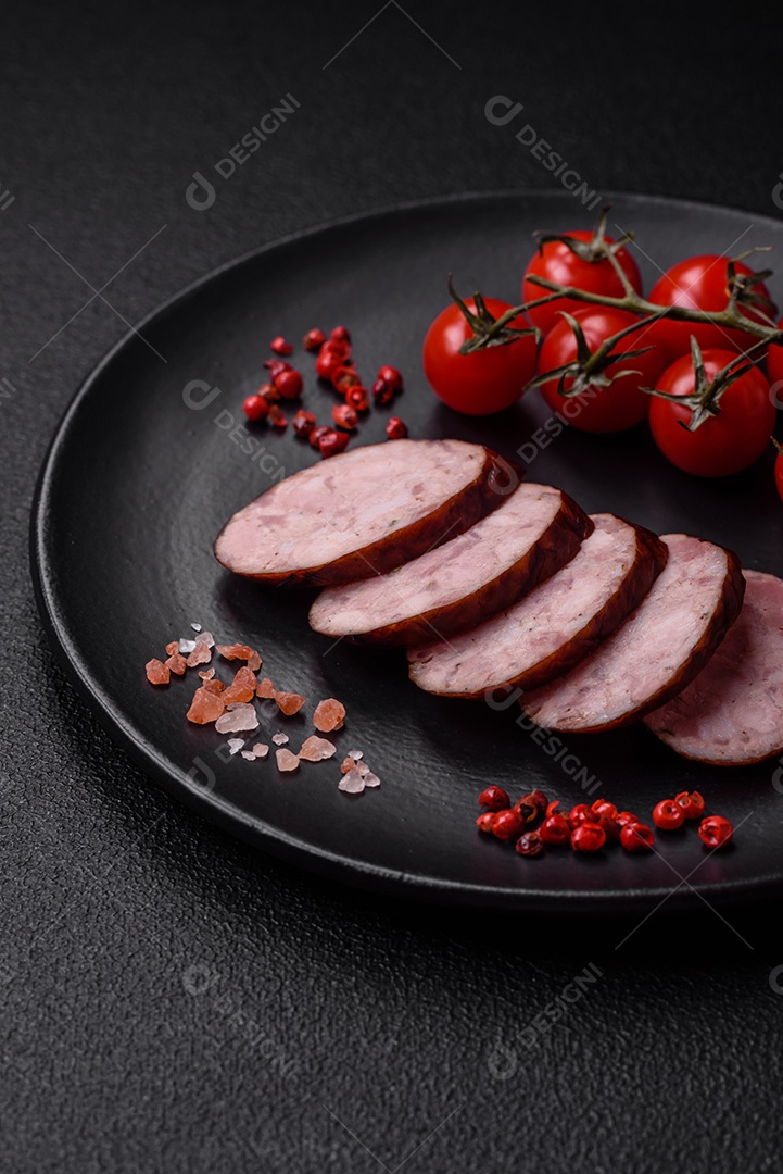 Deliciosa salsicha defumada com sal e especiarias cortadas em fatias sobre um fundo escuro de concreto