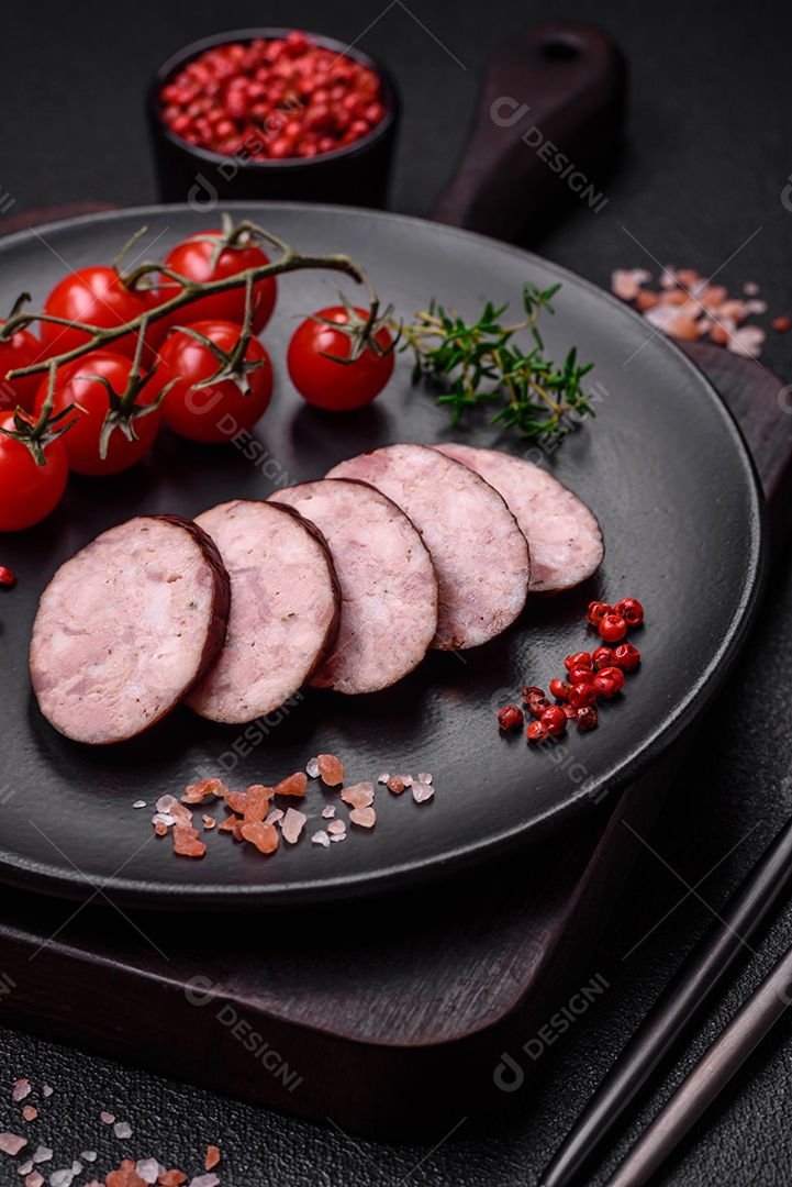 Deliciosa salsicha defumada com sal e especiarias cortadas em fatias sobre um fundo escuro de concreto