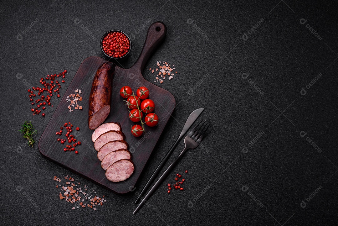 Deliciosa salsicha defumada com sal e especiarias cortadas em fatias sobre um fundo escuro de concreto