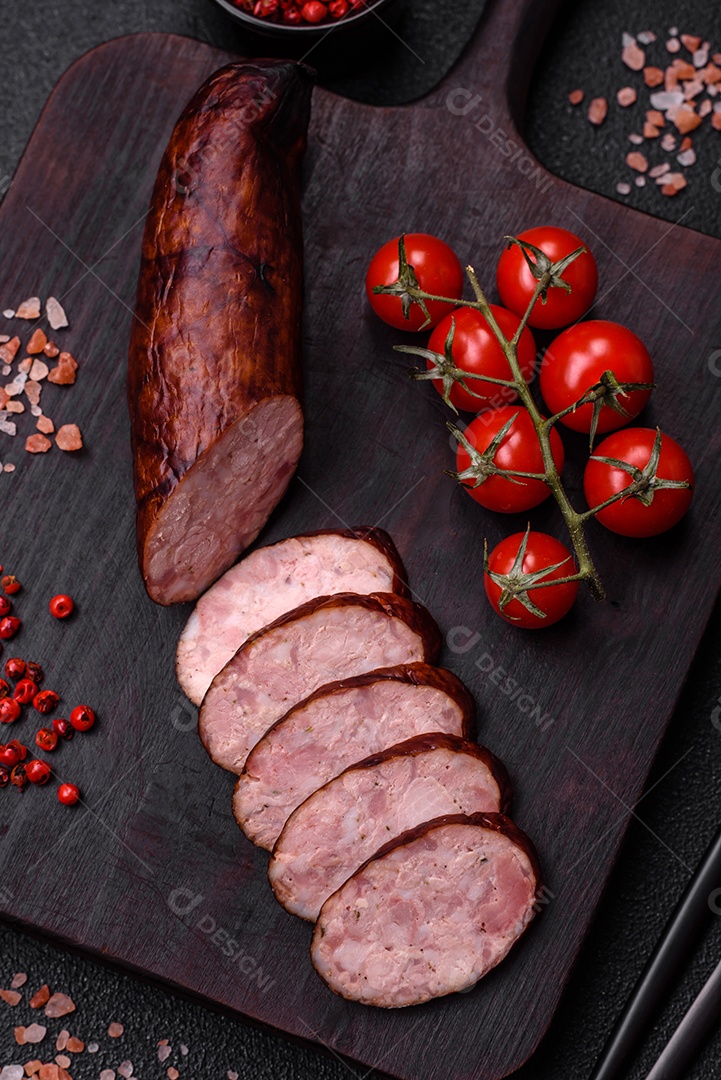 Deliciosa salsicha defumada com sal e especiarias cortadas em fatias sobre um fundo escuro de concreto