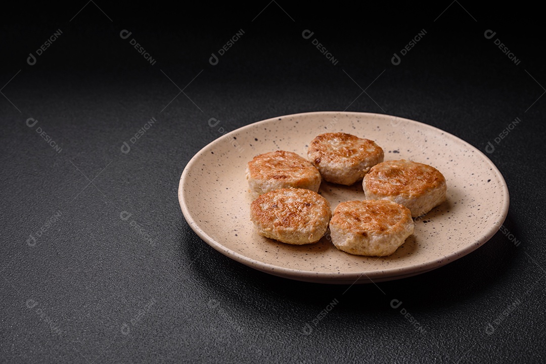 Almôndegas fritas de carne picada, carne de porco ou frango com sal, especiarias e ervas sobre um fundo escuro de concreto