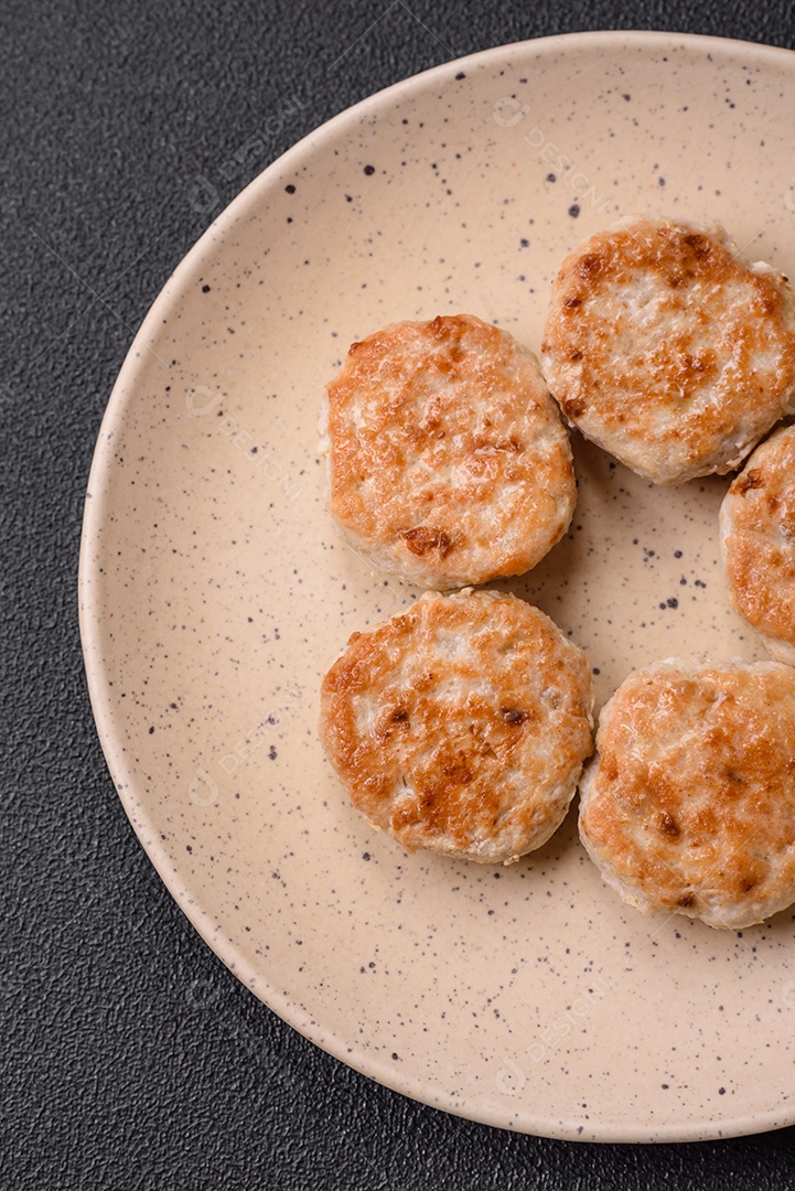 Almôndegas fritas de carne picada, carne de porco ou frango com sal, especiarias e ervas sobre um fundo escuro de concreto