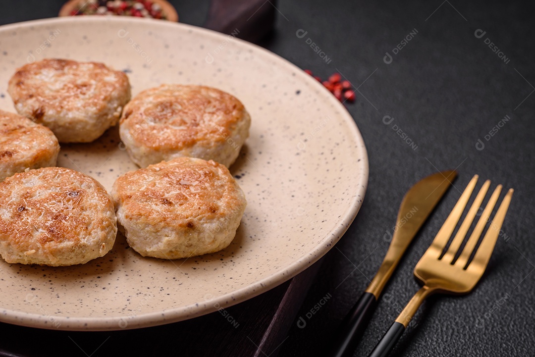 Almôndegas fritas de carne picada, carne de porco ou frango com sal, especiarias e ervas sobre um fundo escuro de concreto
