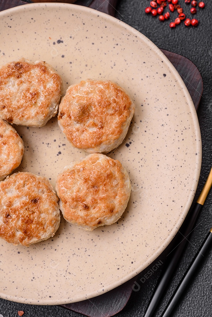 Almôndegas fritas de carne picada, carne de porco ou frango com sal, especiarias e ervas sobre um fundo escuro de concreto