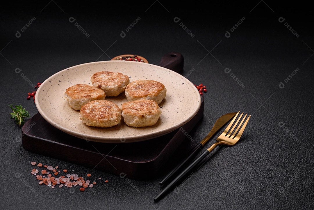 Almôndegas fritas de carne picada, carne de porco ou frango com sal, especiarias e ervas sobre um fundo escuro de concreto