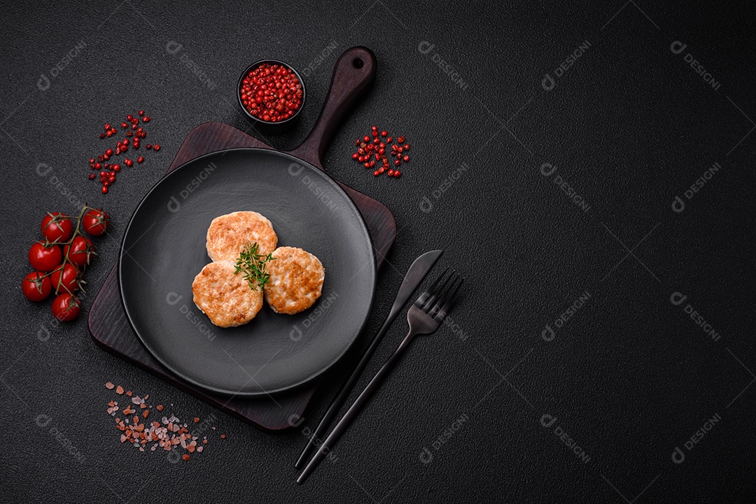 Almôndegas fritas de carne picada, carne de porco ou frango com sal, especiarias e ervas sobre um fundo escuro de concreto