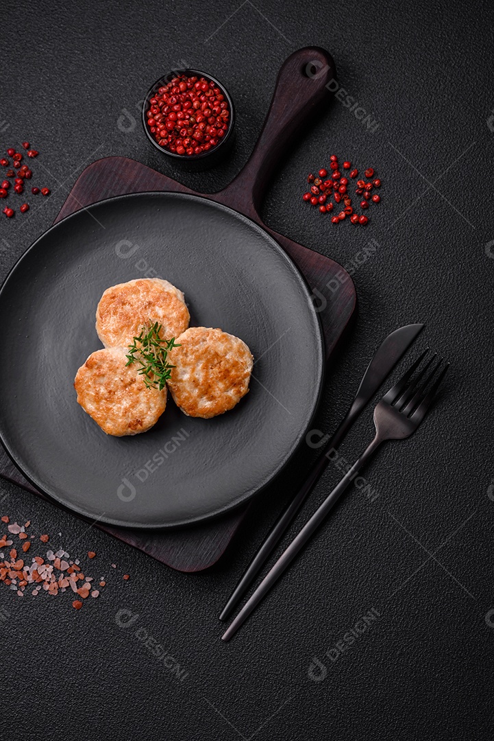 Almôndegas fritas de carne picada, carne de porco ou frango com sal, especiarias e ervas sobre um fundo escuro de concreto