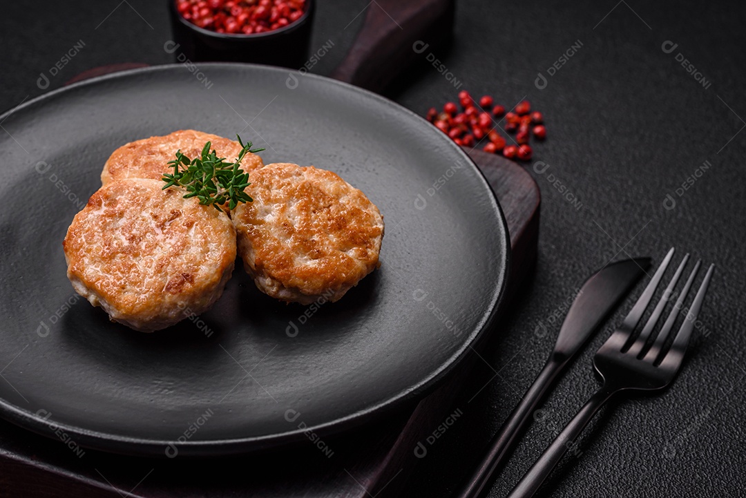 Almôndegas fritas de carne picada, carne de porco ou frango com sal, especiarias e ervas sobre um fundo escuro de concreto