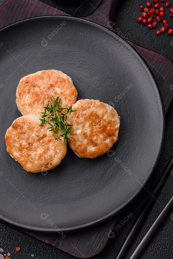 Almôndegas fritas de carne picada, carne de porco ou frango com sal, especiarias e ervas sobre um fundo escuro de concreto