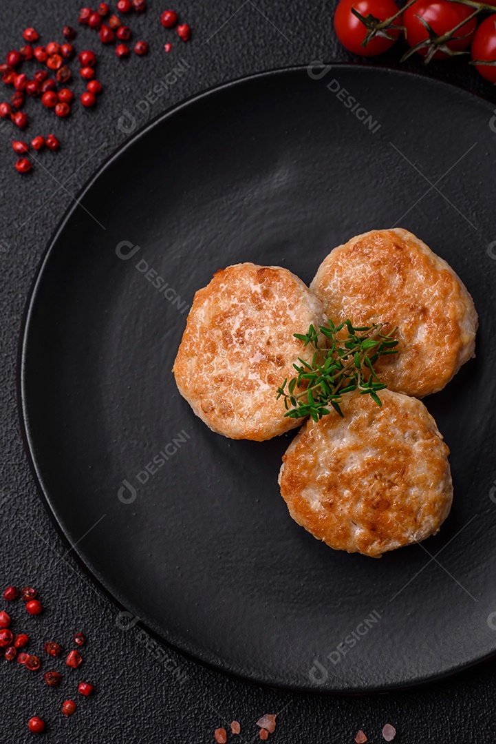 Almôndegas fritas de carne picada, carne de porco ou frango com sal, especiarias e ervas sobre um fundo escuro de concreto