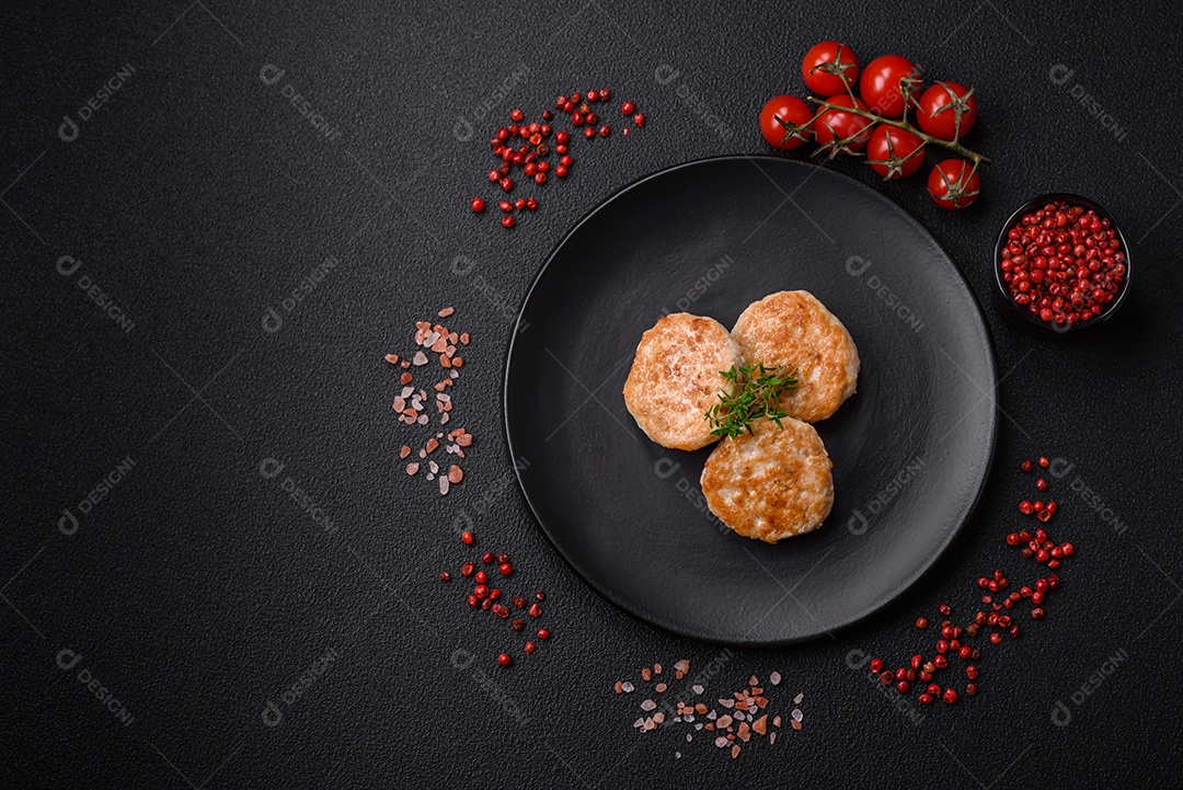 Almôndegas fritas de carne picada, carne de porco ou frango com sal, especiarias e ervas sobre um fundo escuro de concreto