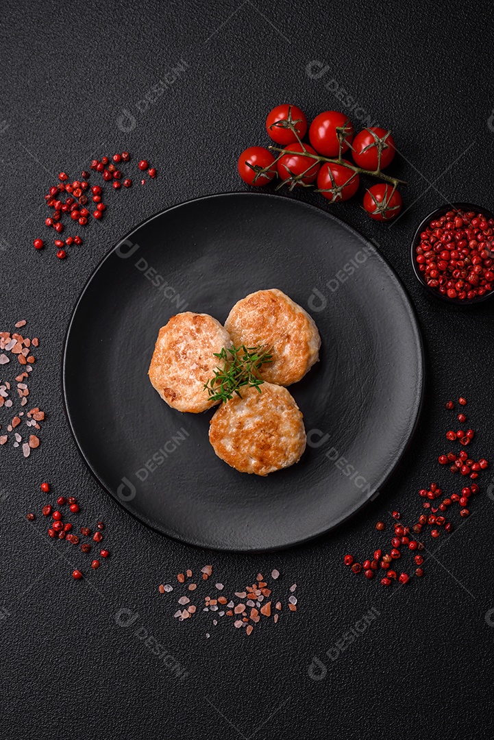 Almôndegas fritas de carne picada, carne de porco ou frango com sal, especiarias e ervas sobre um fundo escuro de concreto