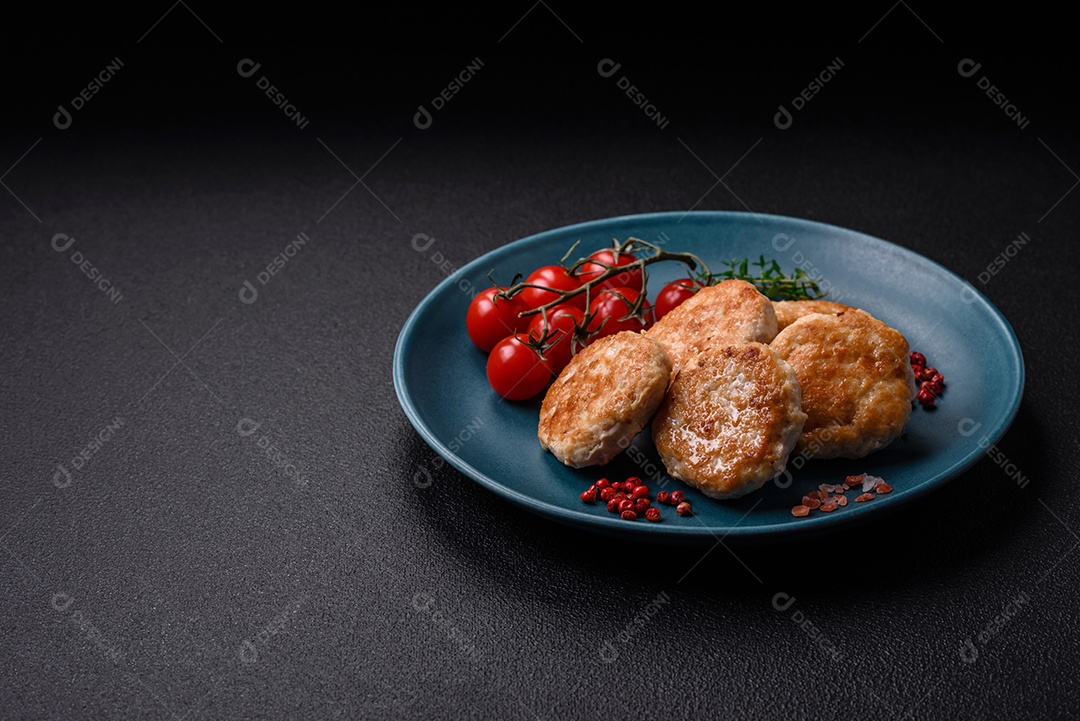 Almôndegas fritas de carne picada, carne de porco ou frango com sal, especiarias e ervas sobre um fundo escuro de concreto