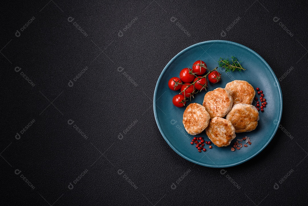 Almôndegas fritas de carne picada, carne de porco ou frango com sal, especiarias e ervas sobre um fundo escuro de concreto