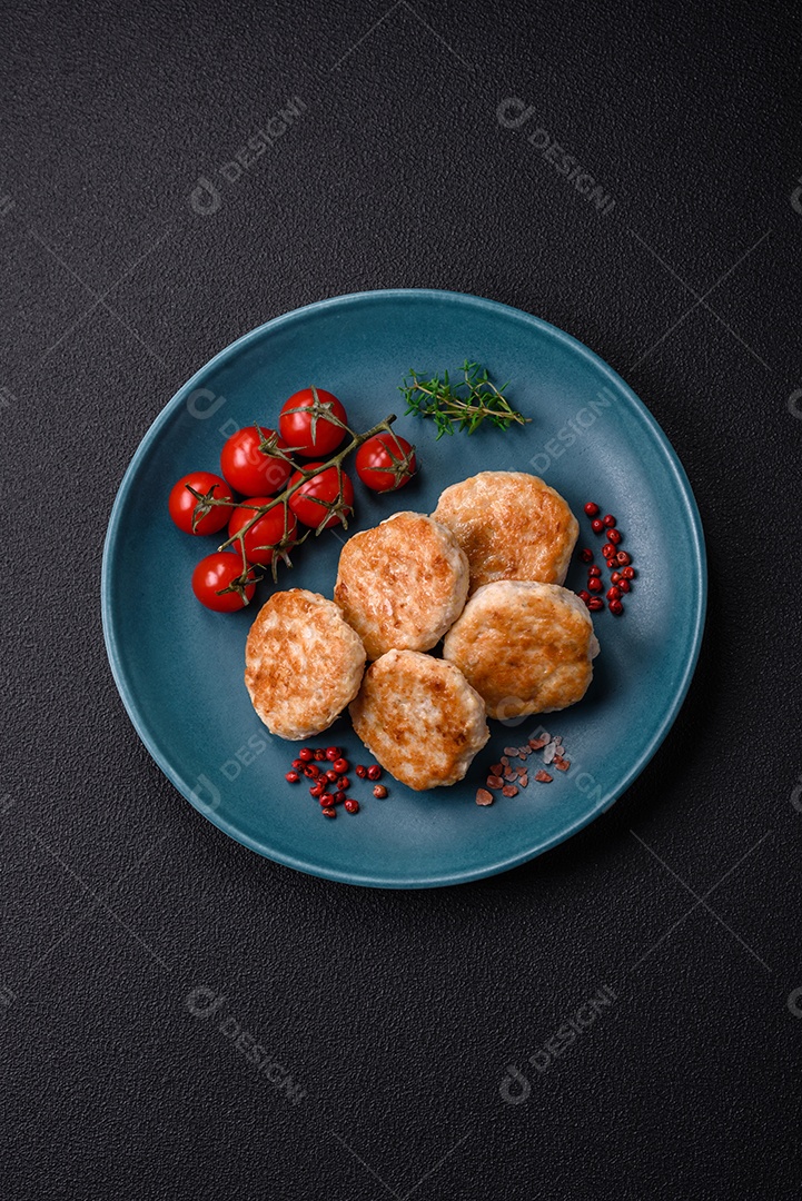 Almôndegas fritas de carne picada, carne de porco ou frango com sal, especiarias e ervas sobre um fundo escuro de concreto