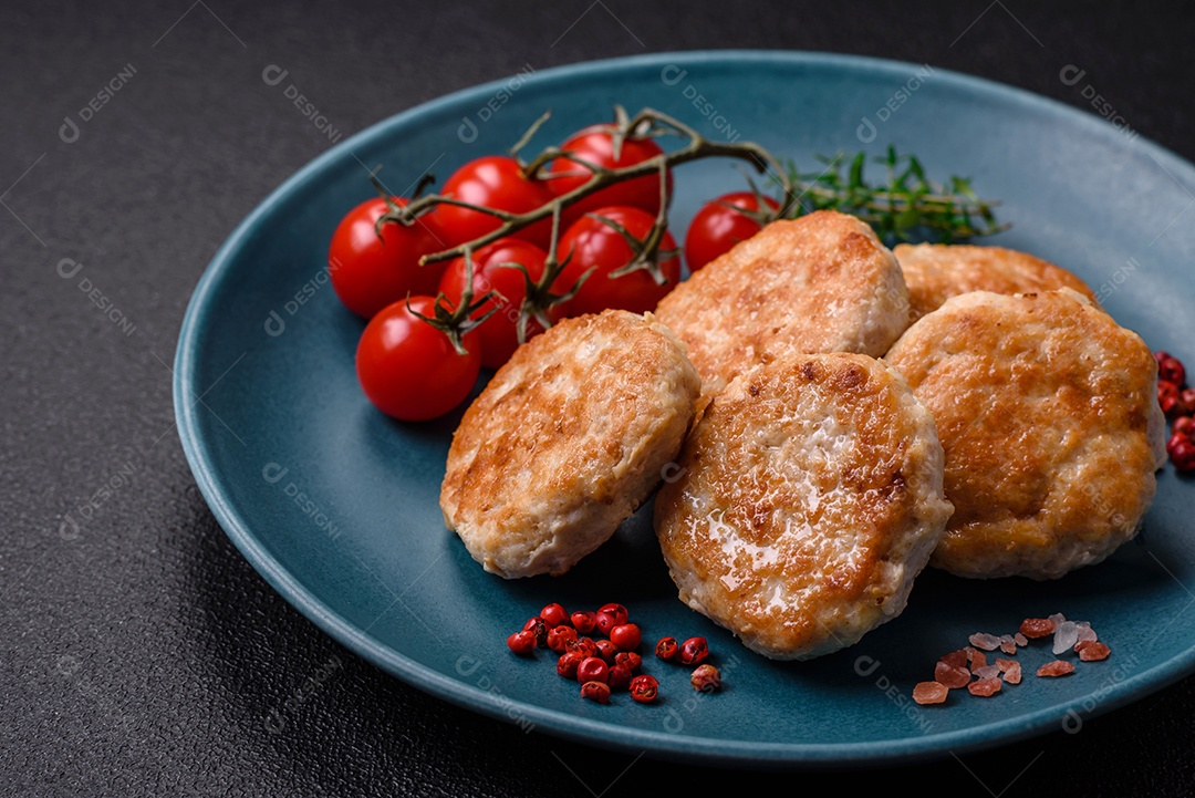 Almôndegas fritas de carne picada, carne de porco ou frango com sal, especiarias e ervas sobre um fundo escuro de concreto