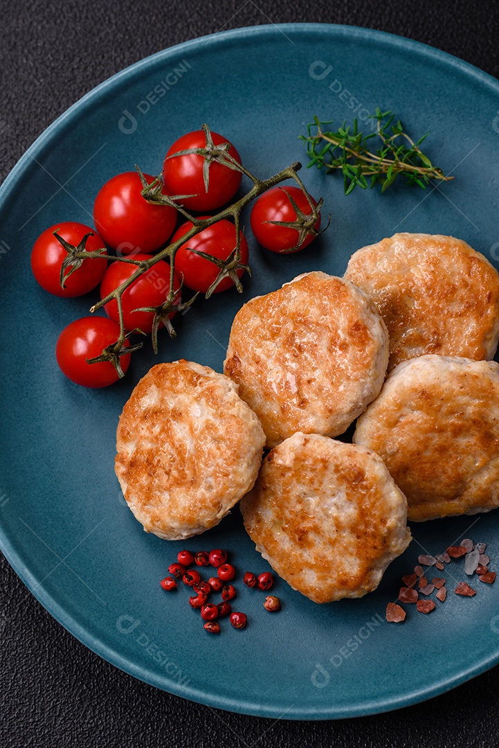 Almôndegas fritas de carne picada, carne de porco ou frango com sal, especiarias e ervas sobre um fundo escuro de concreto