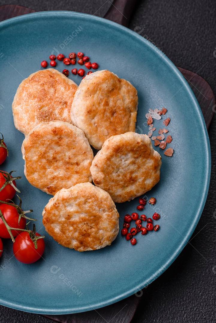 Almôndegas fritas de carne picada, carne de porco ou frango com sal, especiarias e ervas sobre um fundo escuro de concreto