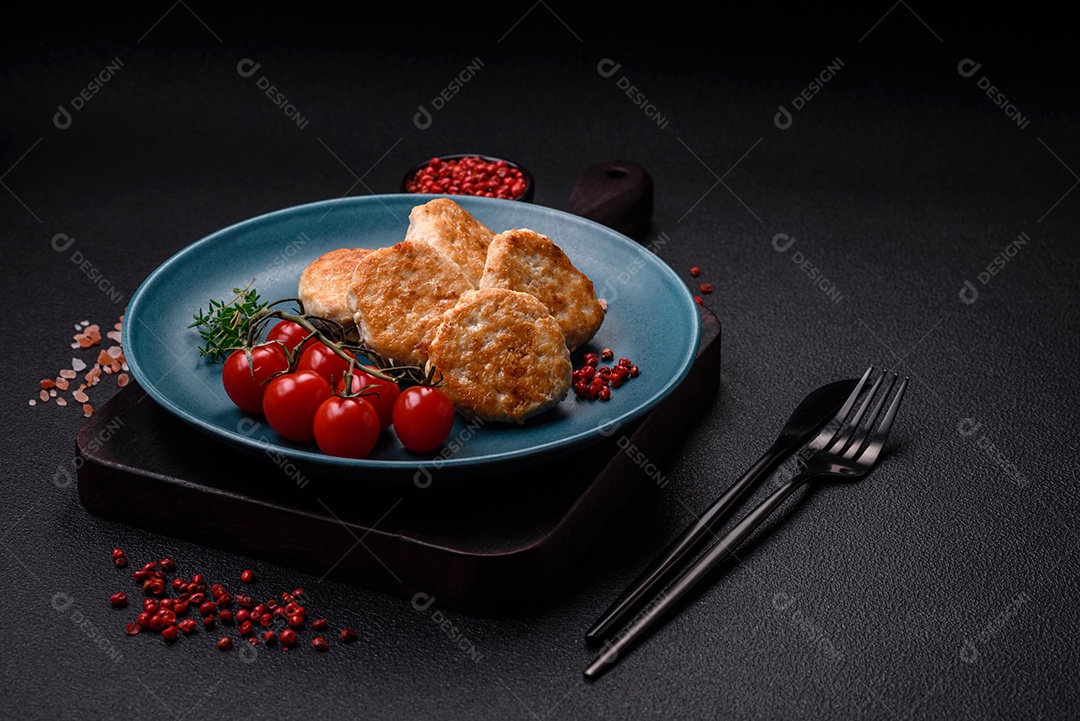 Almôndegas fritas de carne picada, carne de porco ou frango com sal, especiarias e ervas sobre um fundo escuro de concreto