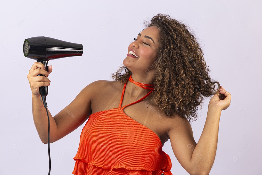 Linda mulher jovem segurando secador de cabelo