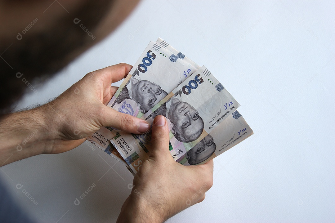 Mão masculina conta seu dinheiro em uma mesa branca