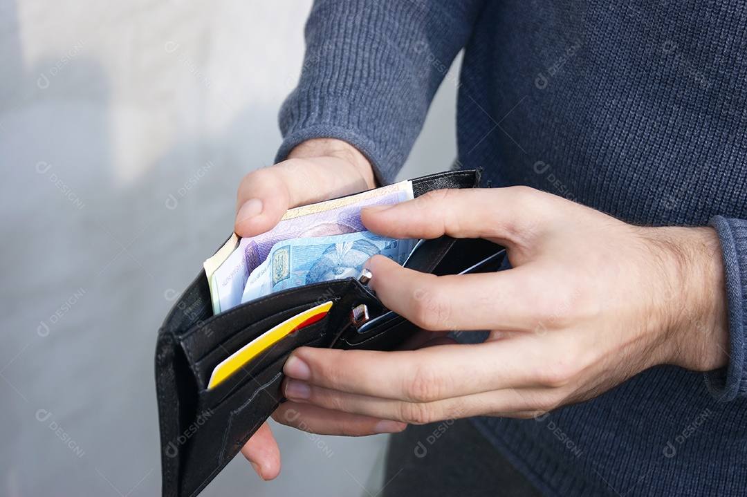 Homem co carteira cheia de dinheiro e cartão nas mãos