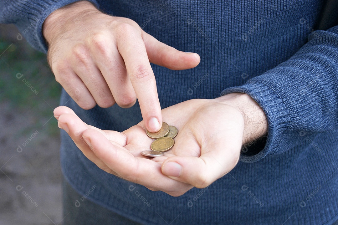 Homem contando moedas europeias nas mãos