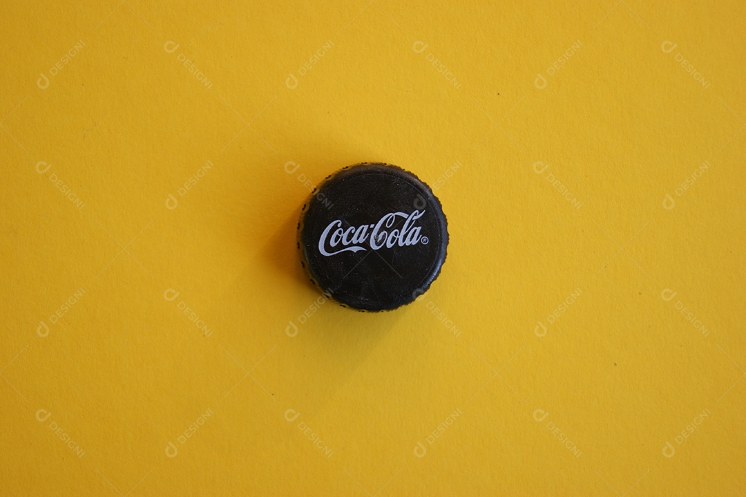 Tampa de garrafa pet de coca cola preta sobre fundo amarelo