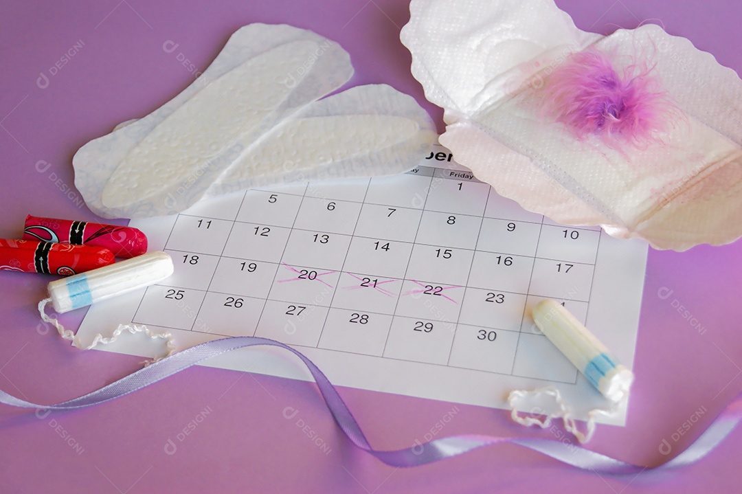 Os absorventes menstruais e tampões no calendário do período menstrual com fundo lilás.