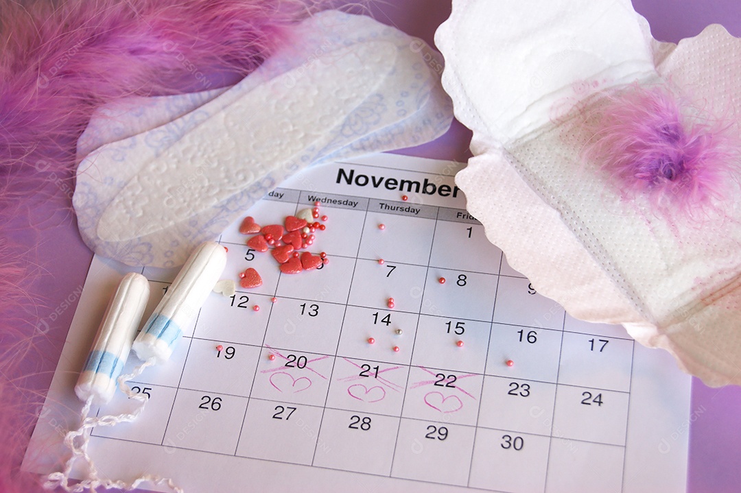 Os absorventes menstruais e tampões no calendário do período menstrual com fundo lilás.