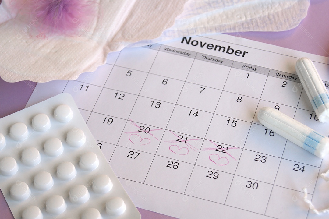 Os absorventes menstruais e tampões no calendário do período menstrual com fundo lilás.