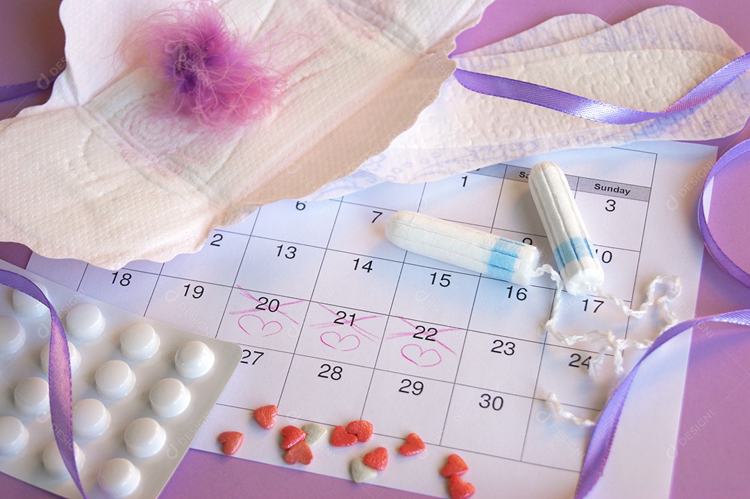 Os absorventes menstruais e tampões no calendário do período menstrual com fundo lilás.