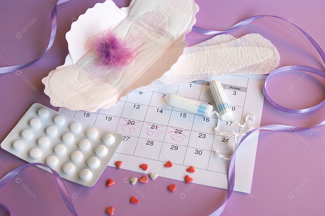 Os absorventes menstruais e tampões no calendário do período menstrual com fundo lilás.