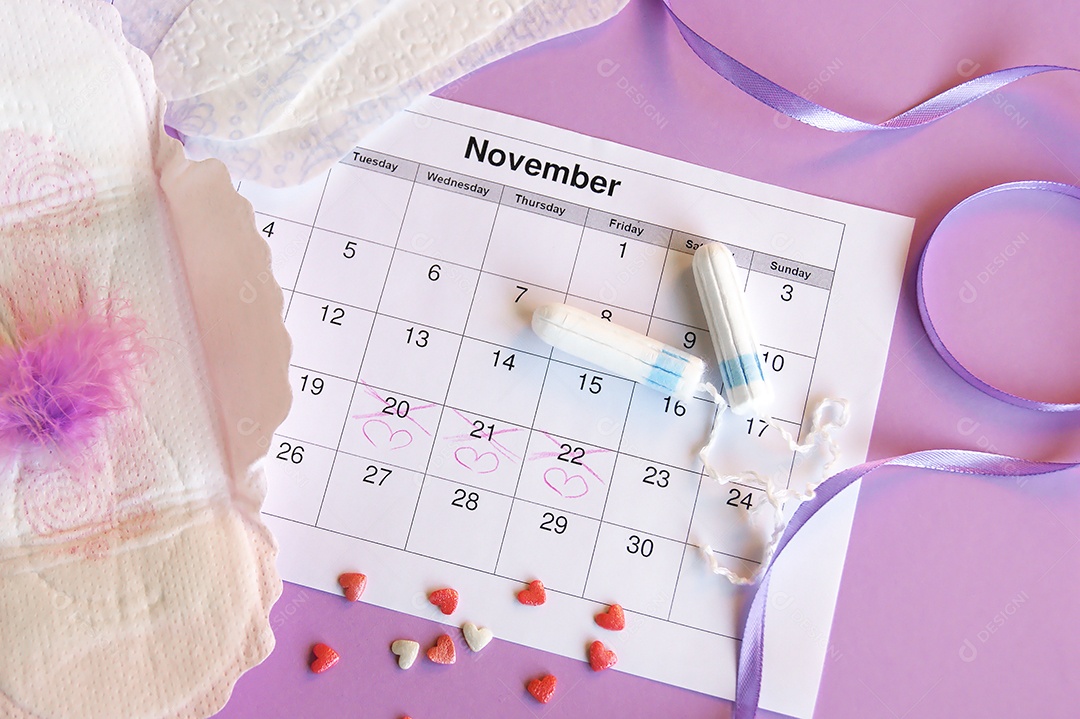 Os absorventes menstruais e tampões no calendário do período menstrual com fundo lilás.