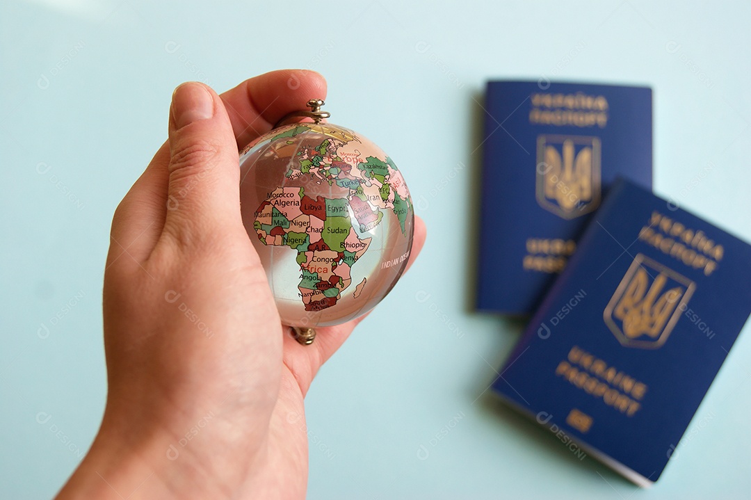 Mão com globo de mundo e passaportes