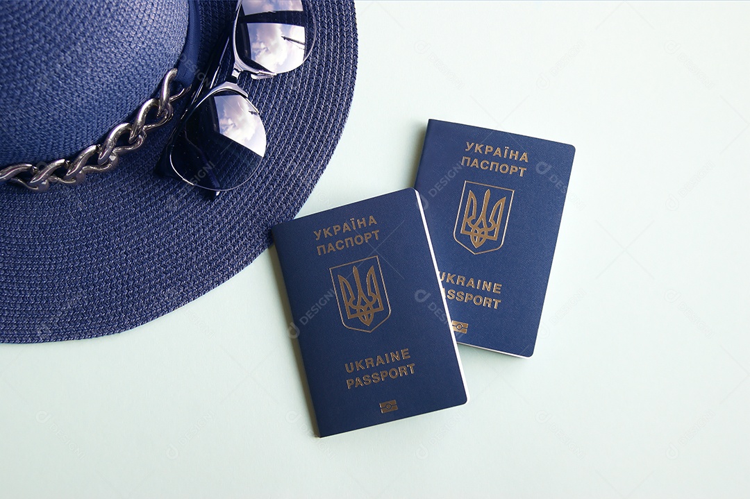 Passaportes óculos encima de chapéu sobre fundo claro