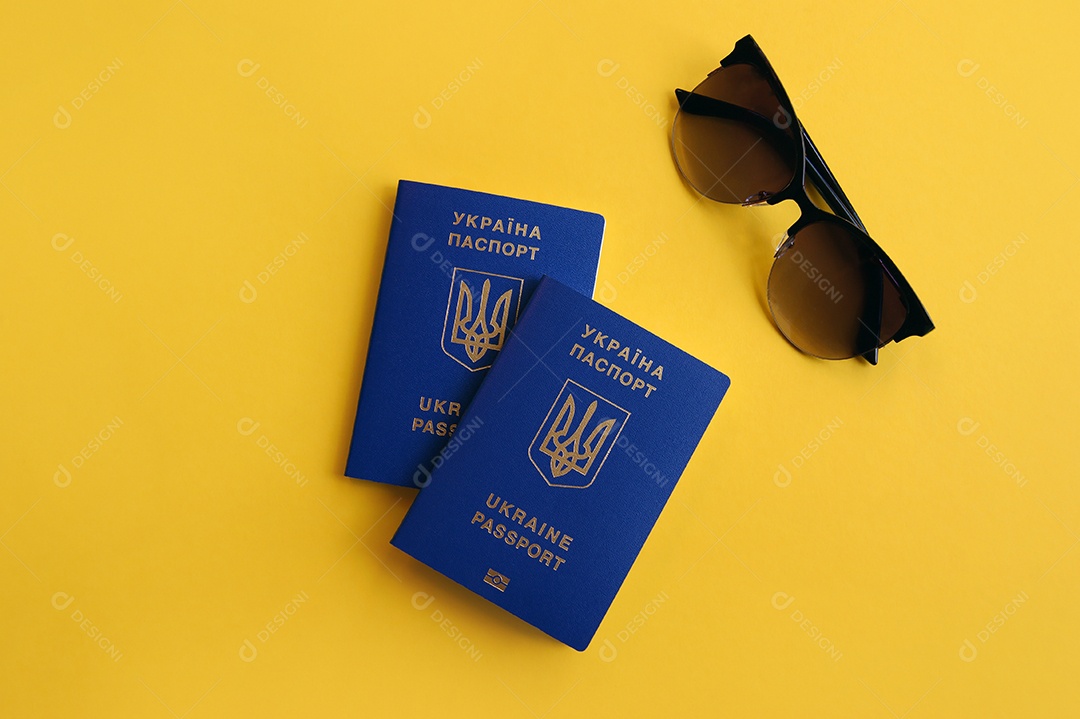 Passaportes e óculos em fundo amarelo