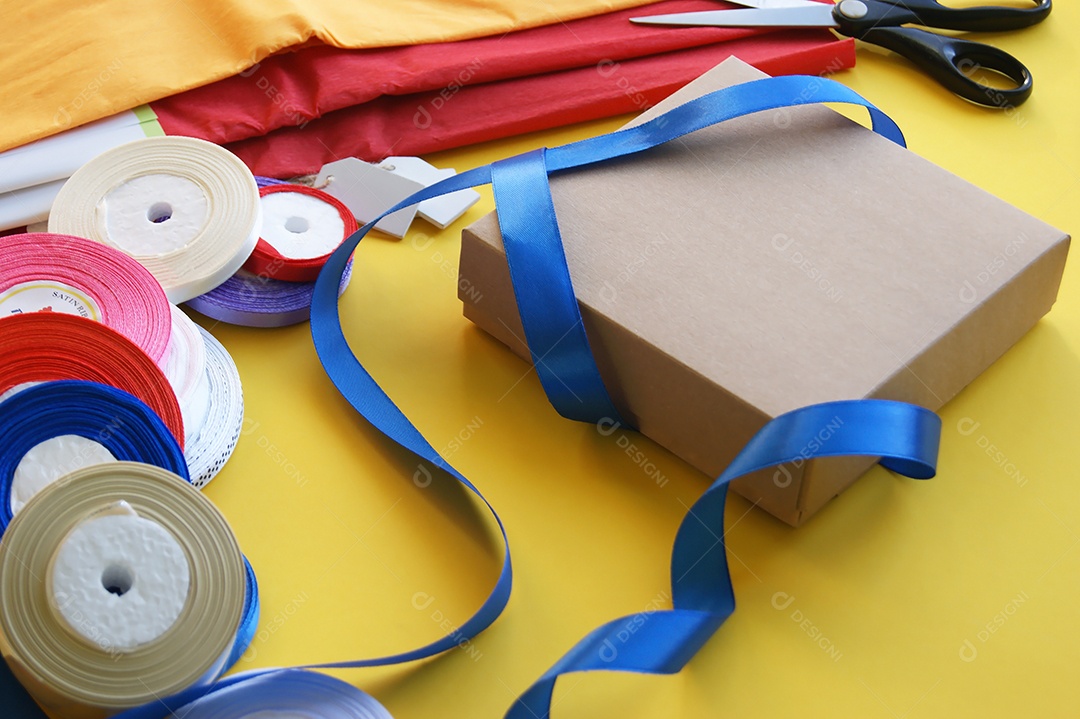Fitas de cetim coloridas ao redor de caixa de presente para decorar
