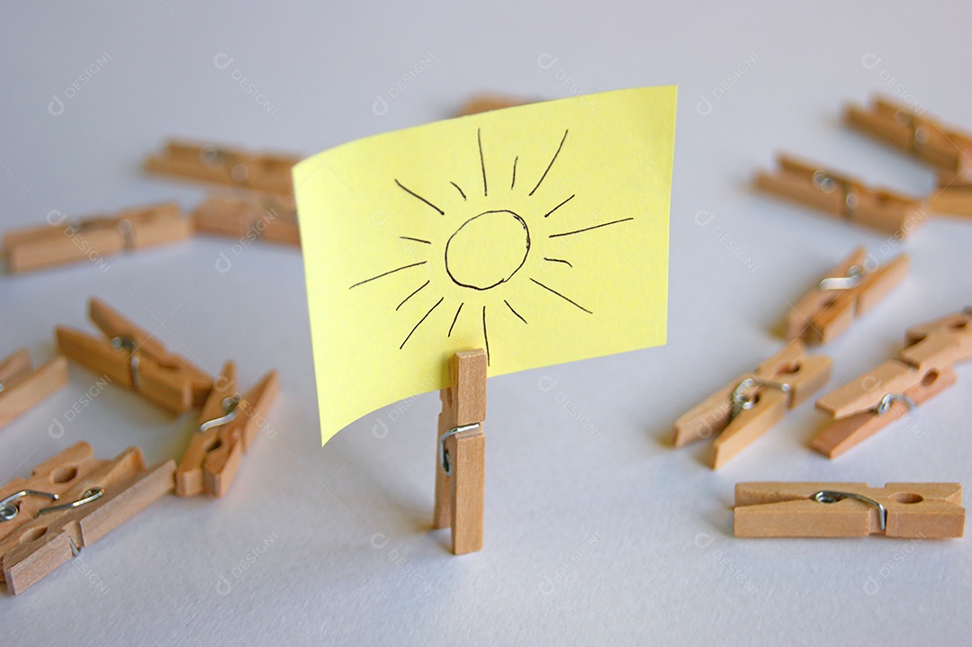 Prendedor com papel escrito e vários prendedor espalhados