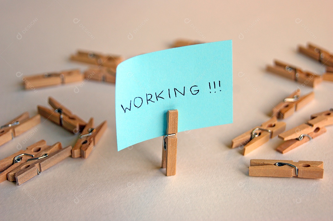 Prendedor com papel escrito e vários prendedor espalhados