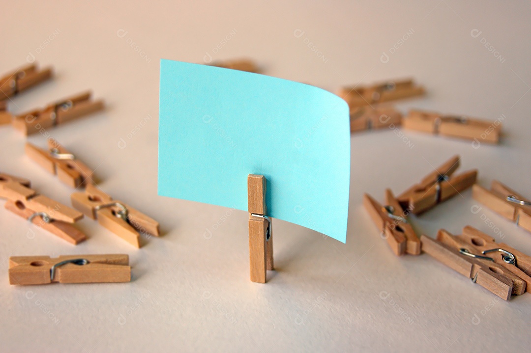 Prendedor com papel escrito e vários prendedor espalhados