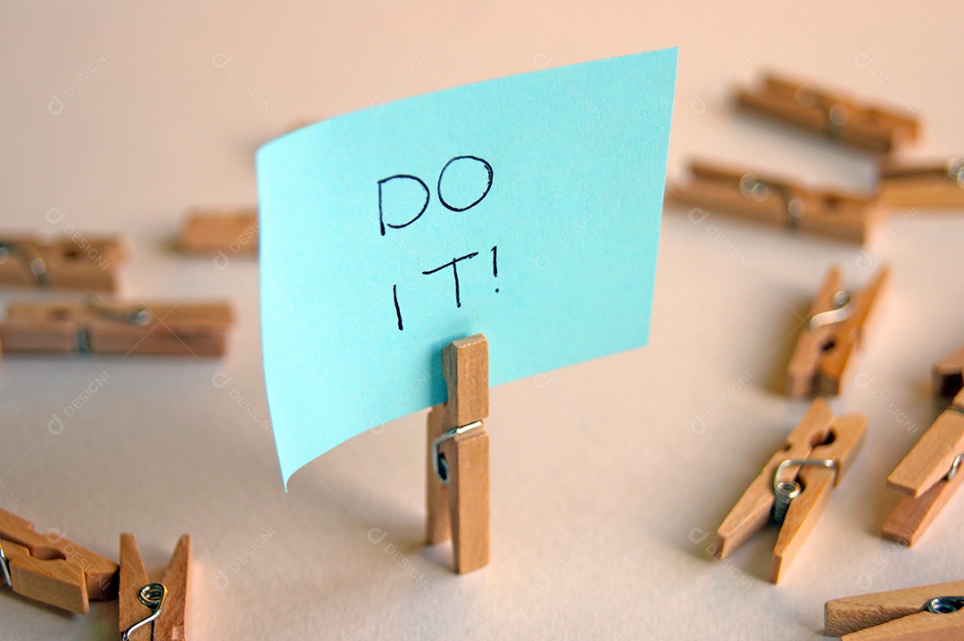 Prendedor com papel escrito e vários prendedor espalhados