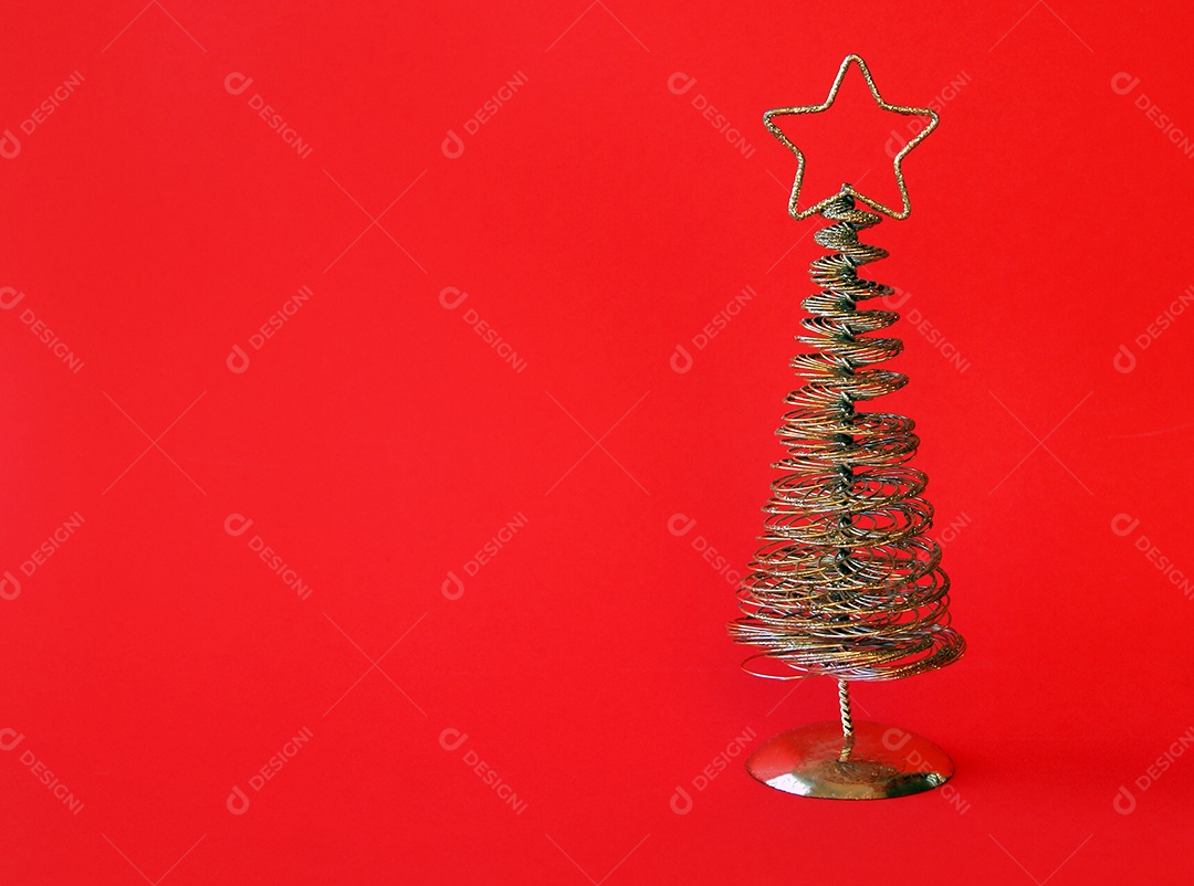 Árvore de Natal de metal dourado com uma estrela no topo fundo vermelho