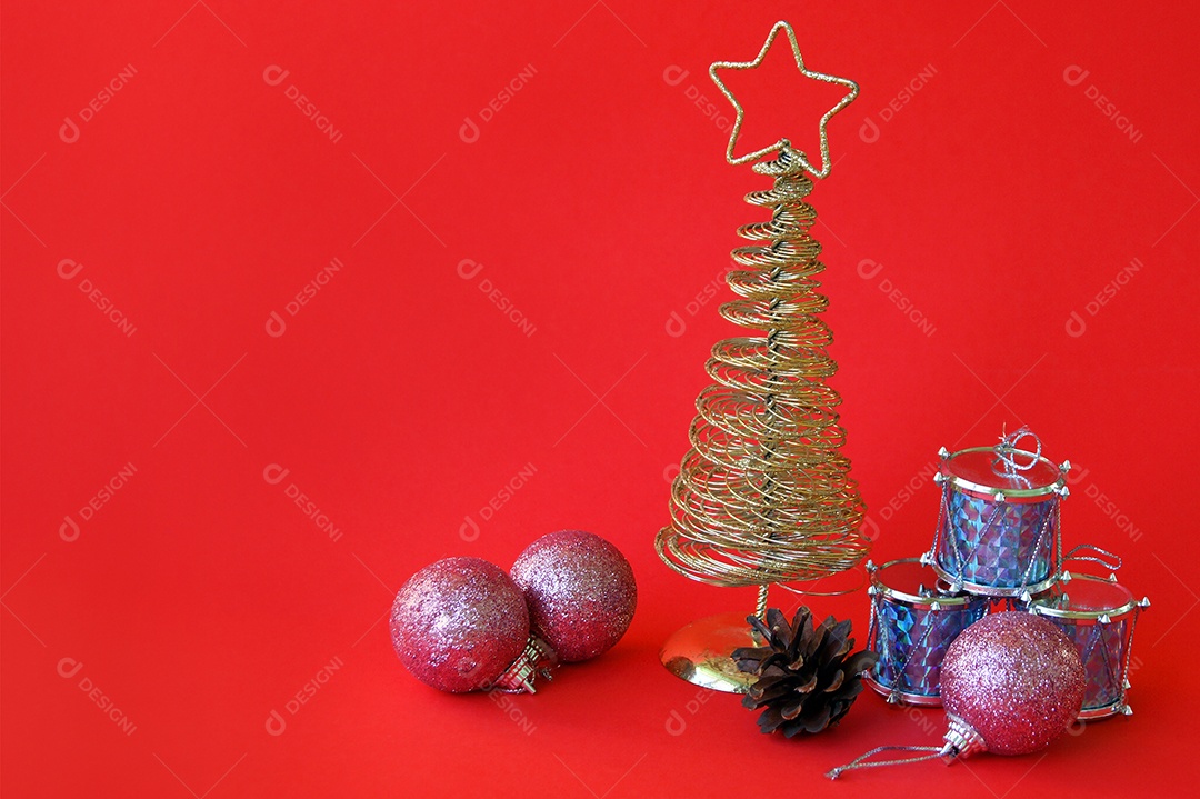 Árvore de Natal dourado com enfeite e presentes sobre fundo vermelho