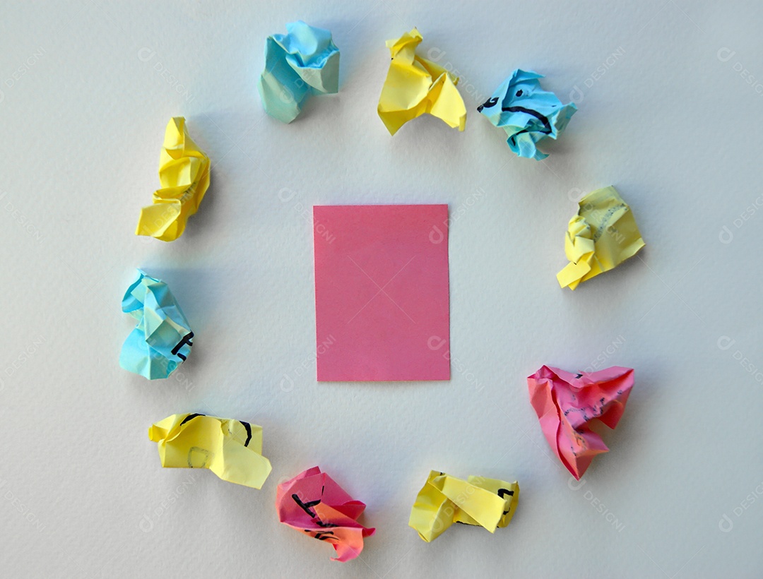 Papel post it limpo ao centro e vários outros amassado ao redor