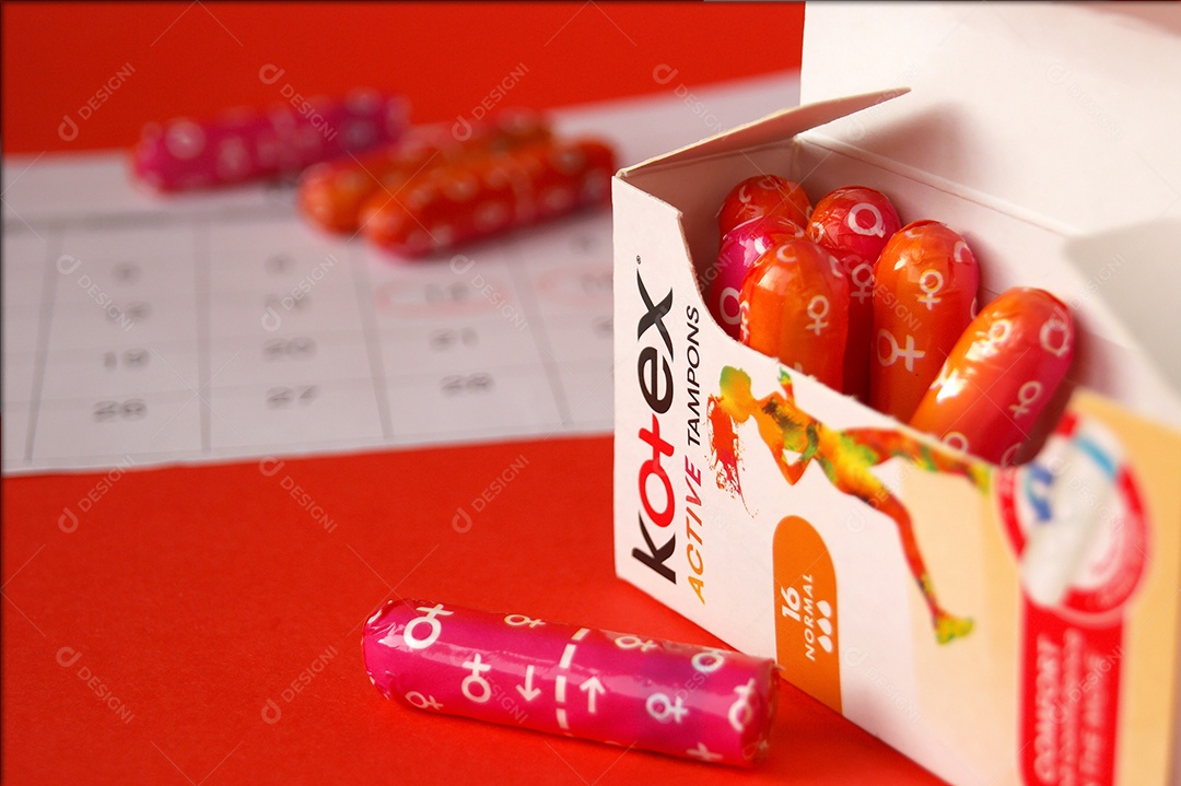 Absorvente interno ob kotex e calendário marcado sobre fundo vermelho